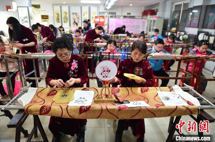 江西省級非遺豫章繡傳承人手把手指導小學生繡制2022年北京冬奧會吉祥物“冰墩墩”形象?！∮髟屏?攝