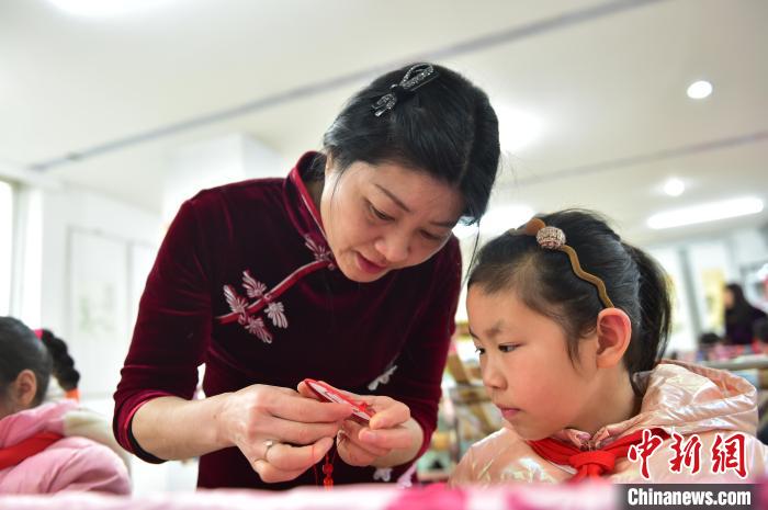 江西省級非遺豫章繡傳承人手把手指導小學生繡制2022年北京冬奧會吉祥物“冰墩墩”形象?！∮髟屏?攝