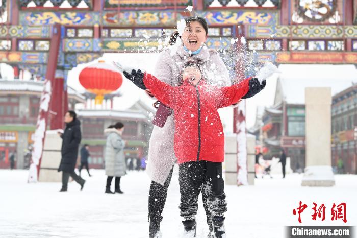 2月13日，家長與小朋友在呼和浩特市大召廣場享雪趣?！⑽娜A 攝