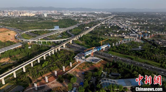 航拍正在建設(shè)的跨越成都繞城高速公路連續(xù)梁施工現(xiàn)場，旁邊依次為已運營的成渝高速鐵路和機場高速公路?！⒅铱?攝