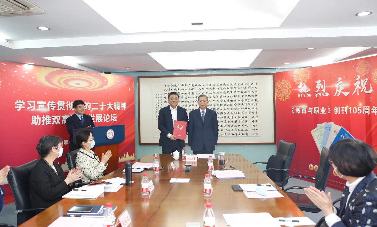 郝明金為《教育與職業(yè)》雜志編委代表陳曉明頒發(fā)聘書(shū)。中華職教社供圖