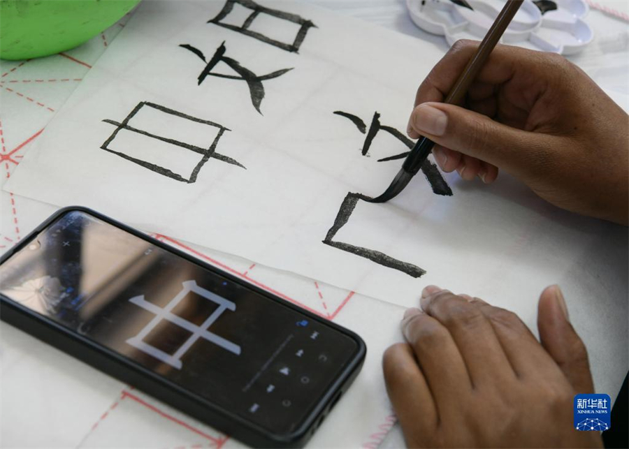 4月18日，肯尼亞學生在內羅畢大學孔子學院舉辦的活動上寫毛筆字?？夏醽唭攘_畢大學孔子學院18日舉辦“中文，增進文明對話”主題活動，慶祝即將到來的第14個聯(lián)合國中文日?？夏醽唽W生參與互動，進行書法、剪紙、唱中文歌等活動。新華社記者 韓旭 攝