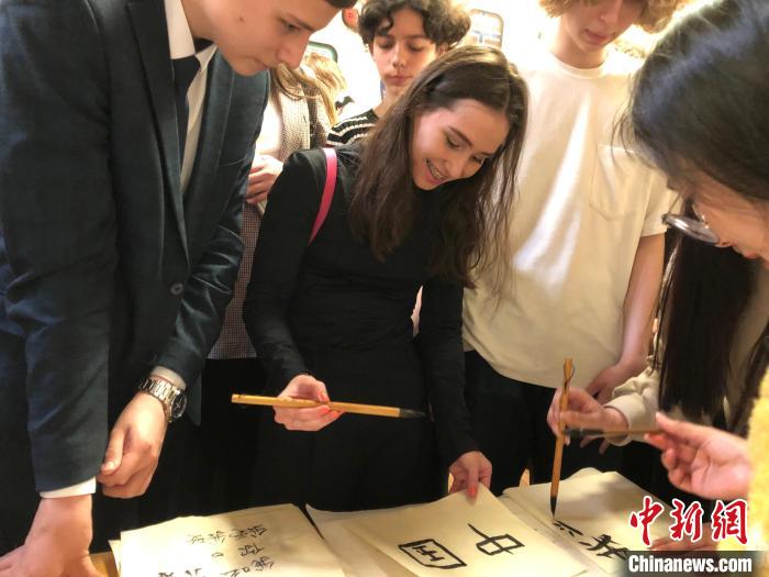4月21日，莫斯科國立語言大學(xué)孔子學(xué)院附屬中學(xué)舉辦“國際中文日”活動(dòng)，學(xué)生們學(xué)寫漢字?！∧箍茋⒄Z言大學(xué)孔子學(xué)院 供圖