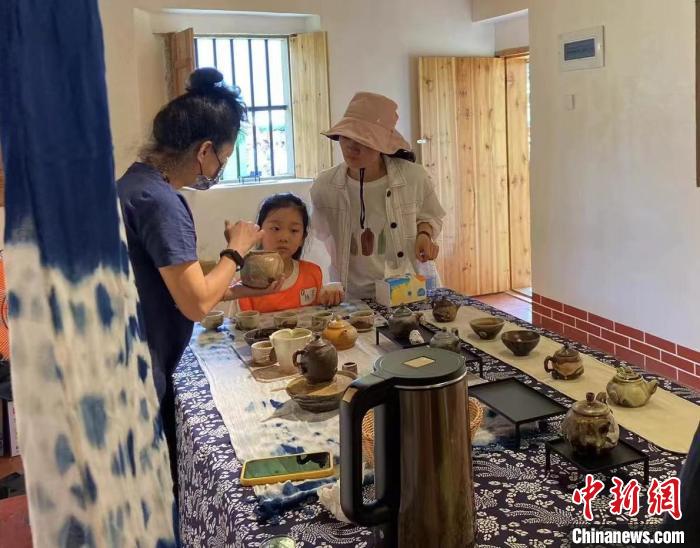 圖為：游客正在咨詢臺灣柴燒作品。　葉秋云 攝