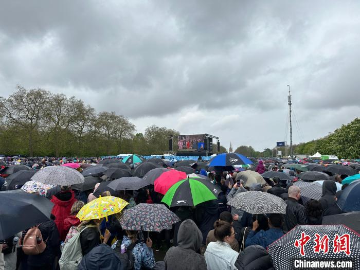 當?shù)貢r間5月6日，英國國王查爾斯三世的加冕儀式舉行。民眾雨中觀看儀式。　歐陽開宇 攝