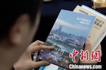 參展觀眾閱讀浙江文旅手冊(cè)?！《≌裾?攝