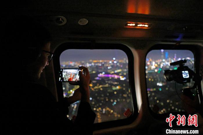 6月3日晚，游客乘坐上海新空直升機(jī)有限公司直升機(jī)開啟鳥瞰黃浦江空中圓夢之旅，并用手機(jī)拍攝城市夜景。　殷立勤 攝