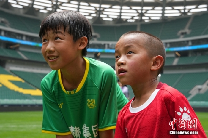 圖為北京國(guó)安小球員陳小北和7歲的俄金仁增在一起觀看場(chǎng)內(nèi)播放的紀(jì)錄片。<a target='_blank' href='/' _fcksavedurl='/'><p  align=