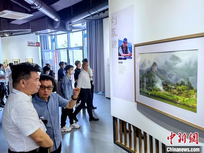 海峽兩岸藝術(shù)家畫(huà)展上，藝術(shù)家進(jìn)行藝術(shù)交流?！「毒窜?攝