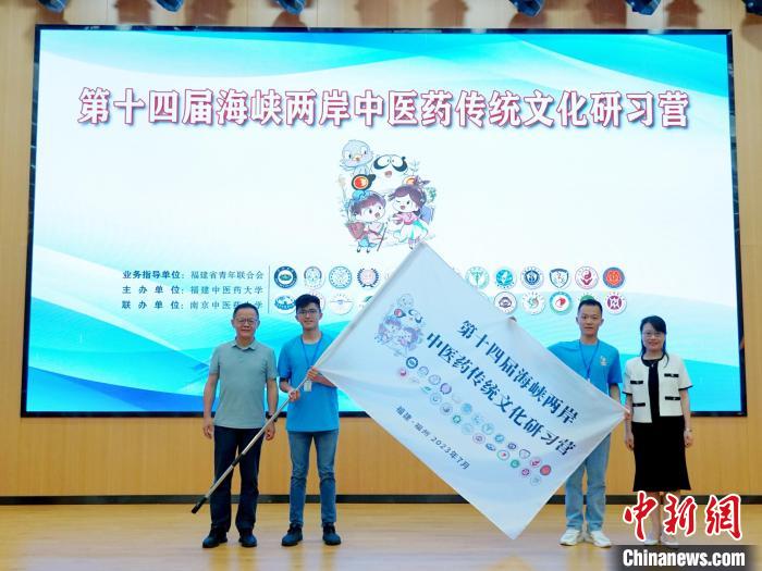 共青團(tuán)福建省委副書(shū)記吳雪(右一)、福建中醫(yī)藥大學(xué)黨委副書(shū)記林羽(左一)為兩岸學(xué)生代表頒授營(yíng)旗。　許燁婷 攝