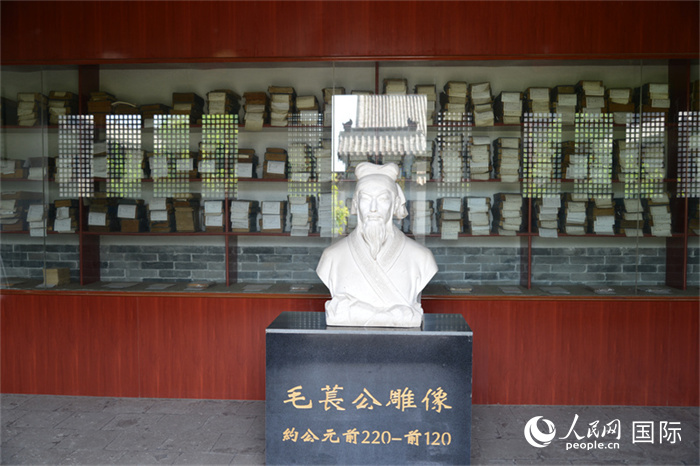河間詩(shī)經(jīng)齋毛萇雕像。雕像后書櫥中陳列的是歷代各版本《詩(shī)經(jīng)》及譯本。 人民網(wǎng) 趙昭攝