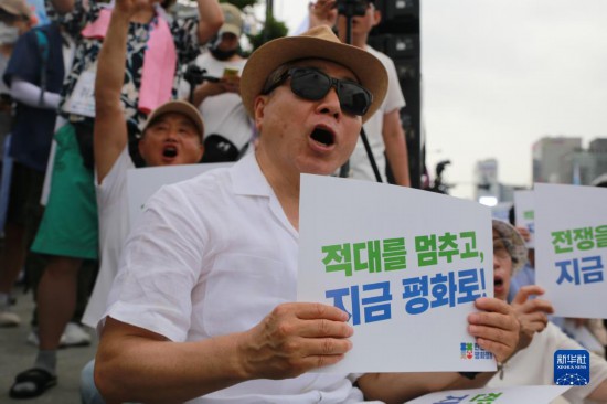 7月22日，在韓國首爾，人們手舉標(biāo)語參與反戰(zhàn)游行。新華社發(fā)（楊暢 攝）
