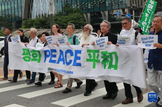 7月22日，在韓國首爾，人們手舉標(biāo)語參與反戰(zhàn)游行。新華社發(fā)（楊暢 攝）
