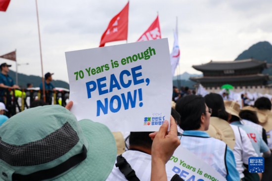 7月22日，在韓國首爾，人們手舉標(biāo)語參與反戰(zhàn)游行。新華社發(fā)（楊暢 攝）