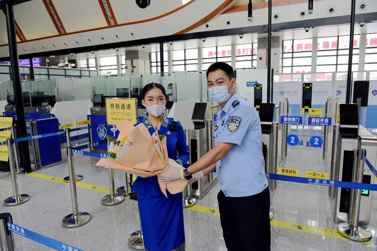 磨憨出入境邊防檢查站民警為中老鐵路第100萬名出入境旅客，D888次國際旅客列車老撾籍乘務員森達拉·妮緹婭（Sengdala Nitiya），送上鮮花。黃遠飛 攝