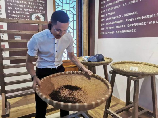 2023“一帶一路”媒體合作論壇聯(lián)合采訪團(tuán)團(tuán)員在非遺文化展示館體驗(yàn)中藥炮制技藝。（本報(bào)記者 黃超攝）