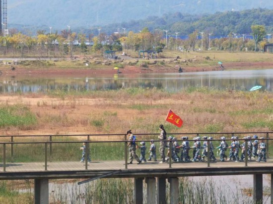　　10月24日，秋游的幼兒園小朋友在老師帶領(lǐng)下走在清水塘公園里的木橋上。本報(bào)記者 常雯宜攝