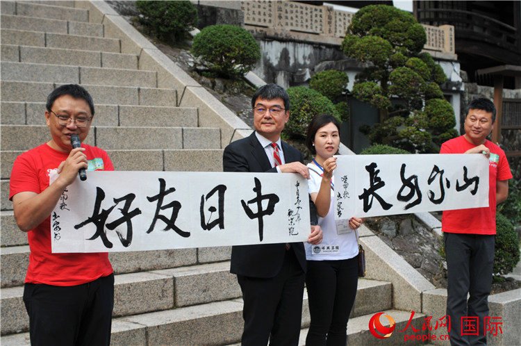 東京中國文化中心主任羅玉泉展示其為本次活動書寫的題詞“中日友好，山高水長”。人民網(wǎng) 蔣曉辰攝