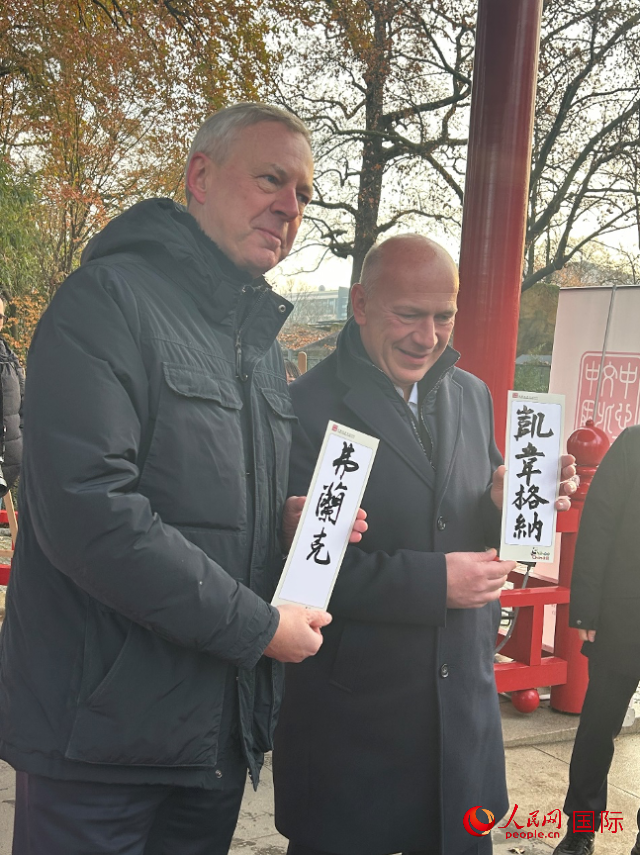 柏林市長(zhǎng)韋格納（右）、動(dòng)物園監(jiān)事會(huì)主席布魯克曼（左）手持中國(guó)文化中心工作人員現(xiàn)場(chǎng)手書的中文名字。人民網(wǎng)記者 徐馨攝