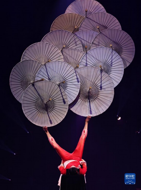 12月8日，演員在法國(guó)巴黎舉行的中國(guó)雜技“奇妙之夜”演出上表演《蹬傘》。新華社記者 高靜 攝
