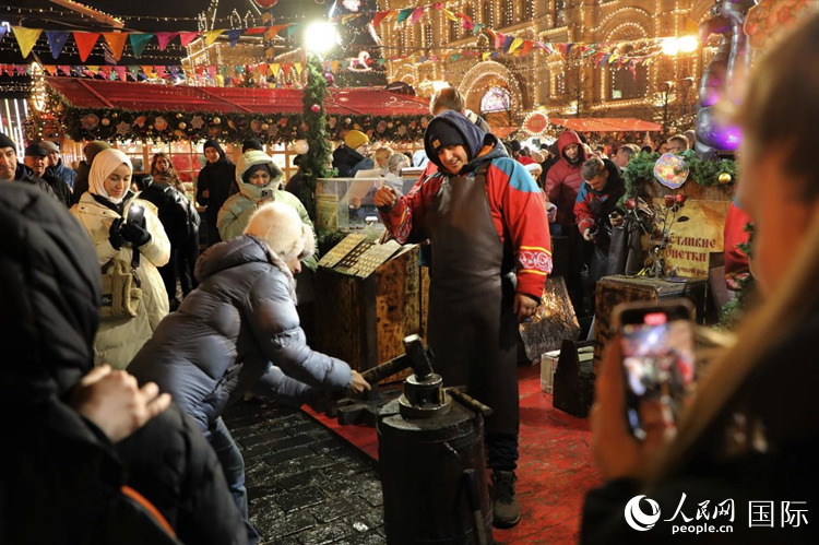 游客在新年集市上體驗(yàn)制作紀(jì)念幣。人民網(wǎng)記者 隋鑫攝