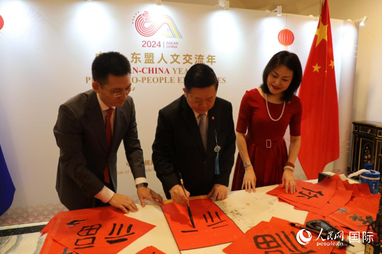 東盟秘書(shū)長(zhǎng)高金洪（中）在活動(dòng)現(xiàn)場(chǎng)寫(xiě)福字。人民網(wǎng)記者曹師韻攝