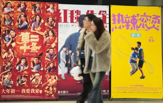 這是2月17日，在沈陽一家影院，觀眾從海報前經(jīng)過。新華社記者李鋼攝
