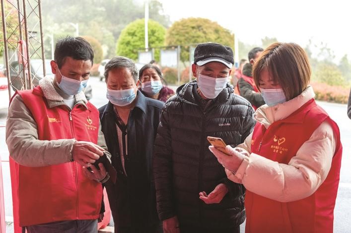 長沙縣黨員志愿者正在幫助參與核酸檢測的群眾掃描“場所碼”。劉思源 攝