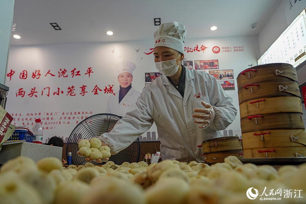 3月31日，在浙江省嵊州市甘霖鎮(zhèn)，嵊州小吃從業(yè)者沈紅平把蒸熟的小籠包晾涼，打包冷藏售賣。人民網(wǎng) 章勇濤攝