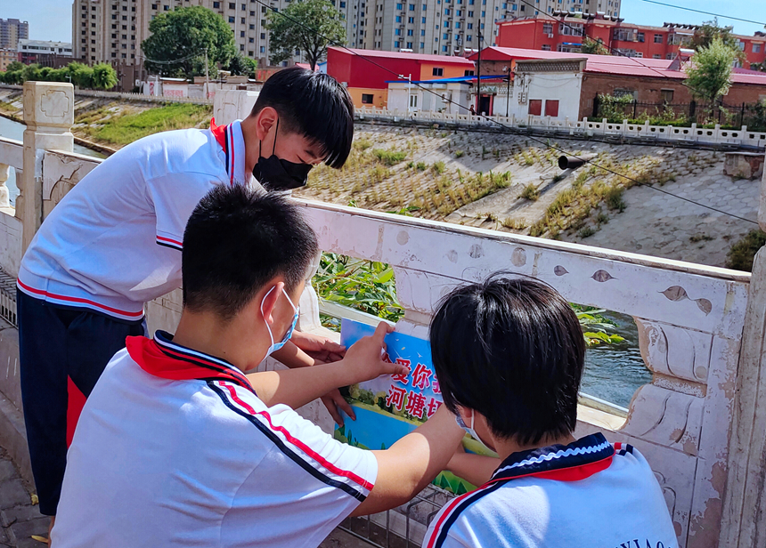 徐水小學(xué)學(xué)雷鋒志愿者在瀑河河邊張貼防溺水警示標(biāo)語。 徐水區(qū)委宣傳部供圖