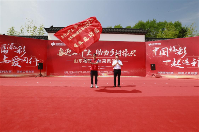 為媒體采風(fēng)團授旗。 山東省福彩供圖