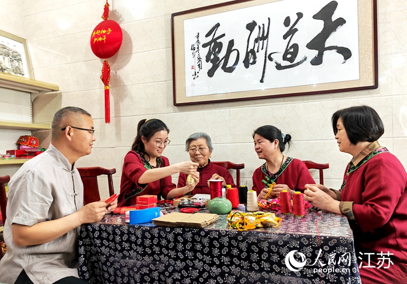 王秀英老人指導(dǎo)孫女制作香包。人民網(wǎng) 閆峰攝