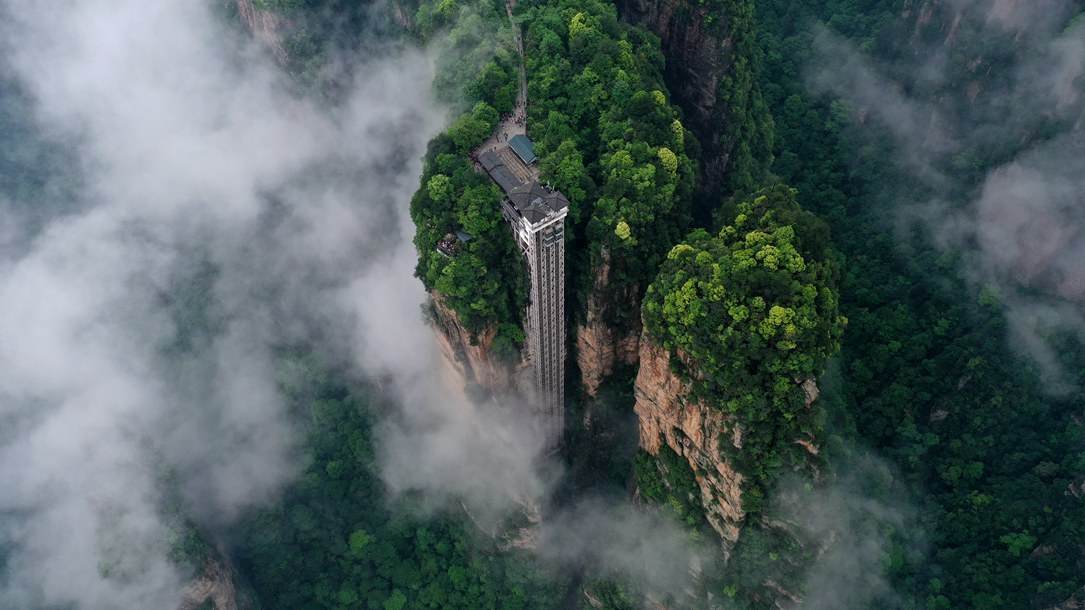 位于張家界武陵源景區(qū)的百龍?zhí)焯蓁偳对谠旗F繚繞的峰林間，雄偉壯觀。吳勇兵攝