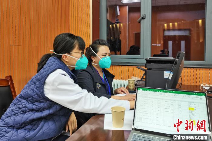 8月9日，楊蘇喬(左)在拉薩方艙醫(yī)院指揮部讀取艙內(nèi)患者胸部CT。　受訪者供圖