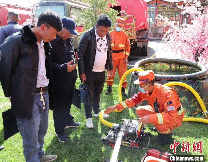 圖為森林消防員為護林員講解滅火裝備的使用方法?！〔际猩窒乐ш?供圖