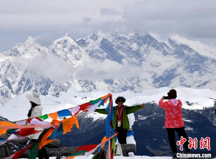 圖為5月14日，西藏林芝色季拉山觀景臺(tái)，游客與南迦巴瓦峰合影?！±盍?攝