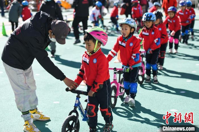 圖為拉薩市實(shí)驗(yàn)幼兒園孩子們在教練的指導(dǎo)下練習(xí)滑步車?！『闻罾?攝