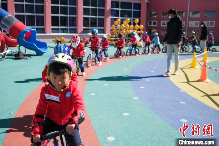 圖為拉薩市實(shí)驗(yàn)幼兒園孩子們在教練的指導(dǎo)下練習(xí)滑步車。　何蓬磊 攝