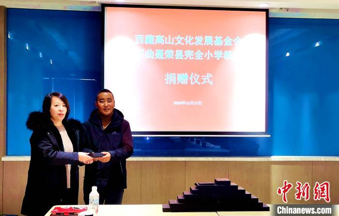 圖為西藏高山文化發(fā)展基金會理事長溫麗向聶榮縣完全小學(xué)負責(zé)人捐助儀器。　于賓 攝