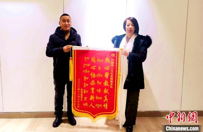 圖為聶榮縣完全小學(xué)向西藏高山文化發(fā)展基金會贈送錦旗?！∮谫e 攝