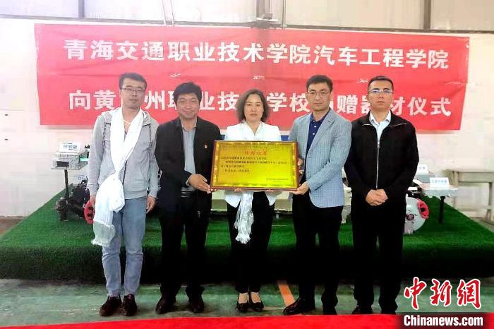 圖為李富香(中)代表學(xué)校為州縣技校捐贈(zèng)器材。(資料圖) 青海省教育廳供圖