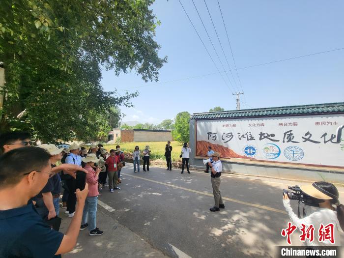 圖為中國地質(zhì)大學(北京)教授張緒教介紹村落情況?！『衍?攝