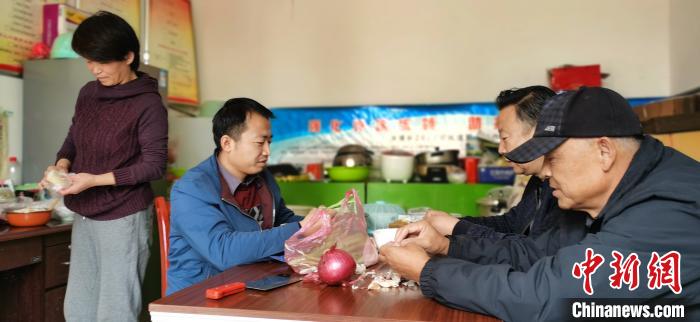 圖為扶貧路上“臨時(shí)一家人”準(zhǔn)備午餐?！∥航ㄜ?攝