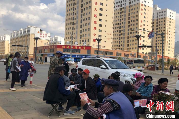 圖為會澤縣城易地扶貧搬遷安置點內(nèi)，老人們聚在廣場上聊天，身后是他們的新家?！】姵?攝