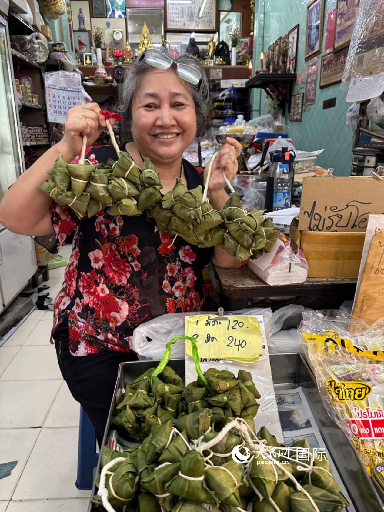 商家向顧客介紹“吉掌”（粽子的一種，一串一串，個(gè)頭較?。?。人民網(wǎng)記者 簡承淵攝