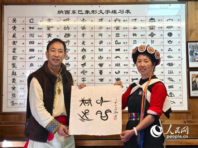 人民網(wǎng)“行進中國”云南調(diào)研采訪團走進麗江，和閏元現(xiàn)場用東巴文寫下“行進中國”。人民網(wǎng)記者 符皓攝