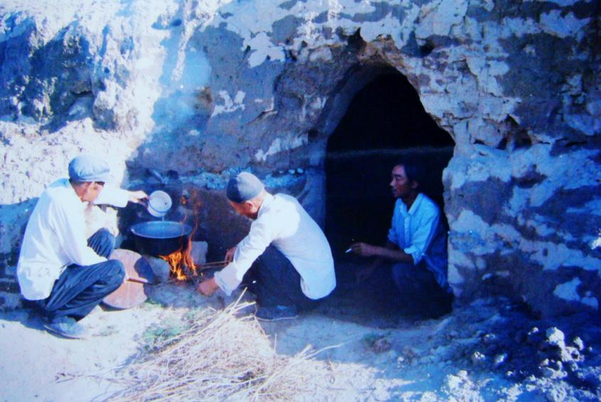 1983年，“六老漢”一代治沙人在“地窩子”生活做飯。新華社發(fā)（八步沙林場供圖）