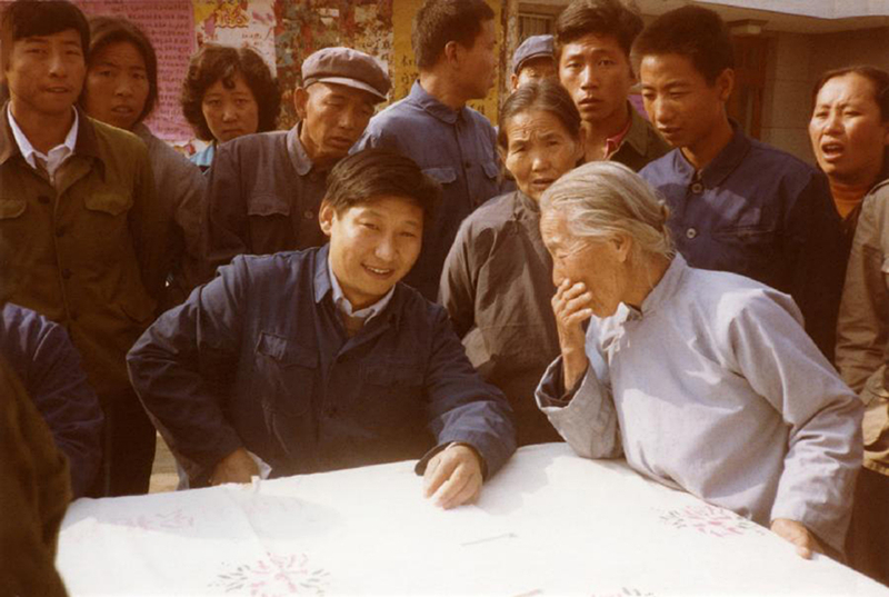 1983年，時(shí)任河北正定縣委書記的習(xí)近平（前排居中），臨時(shí)在大街上擺桌子聽取老百姓意見。