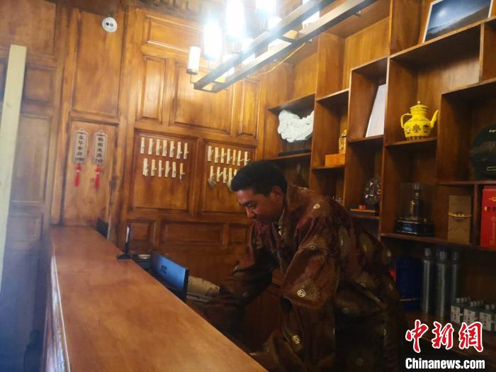 圖為桑杰才讓用電腦處理財務(wù)?！∈缝o靜 攝