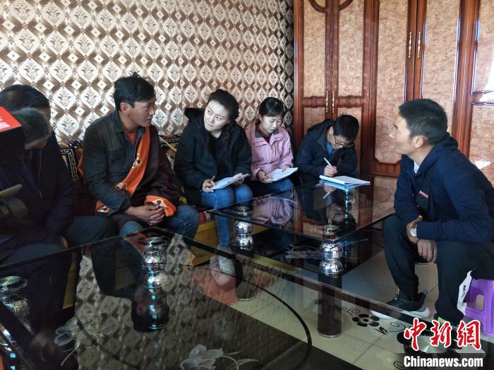 圖為調(diào)查組工作人員正在入戶調(diào)查?！∑钤鲚?攝